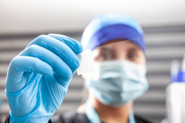 Genç bilim kadını laboratuvarda karyotip ve florasan için slayt hazırlıyor.