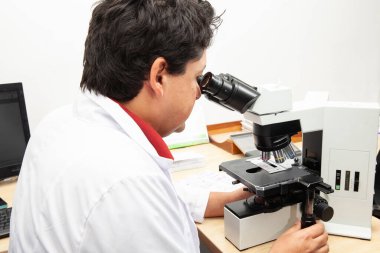 Laboratuvardaki cam kaydıraklarında boyalı doku biyopsisi yapan bir patolog. Kanser tanısı konsepti. Tıbbi konsept.