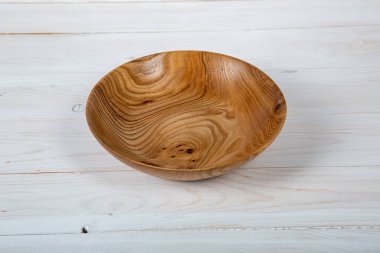 El yapımı ahşap masa takımı ve beyaz tahta arka planda parlak bir ciltli yüzey. Değerli ahşaptan yapılmış sofra takımı..