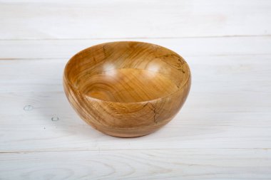 El yapımı ahşap masa takımı ve beyaz tahta arka planda parlak bir ciltli yüzey. Değerli ahşaptan yapılmış sofra takımı..