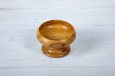 El yapımı ahşap masa takımı ve beyaz tahta arka planda parlak bir ciltli yüzey. Değerli ahşaptan yapılmış sofra takımı..