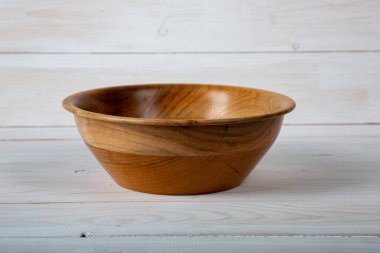 El yapımı ahşap masa takımı ve beyaz tahta arka planda parlak bir ciltli yüzey. Değerli ahşaptan yapılmış sofra takımı..