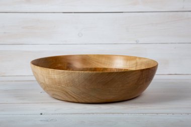 El yapımı ahşap masa takımı ve beyaz tahta arka planda parlak bir ciltli yüzey. Değerli ahşaptan yapılmış sofra takımı..