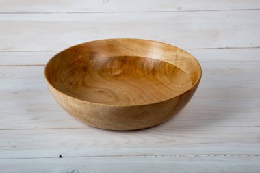 El yapımı ahşap masa takımı ve beyaz tahta arka planda parlak bir ciltli yüzey. Değerli ahşaptan yapılmış sofra takımı..