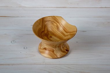 El yapımı ahşap masa takımı ve beyaz tahta arka planda parlak bir ciltli yüzey. Değerli ahşaptan yapılmış sofra takımı..