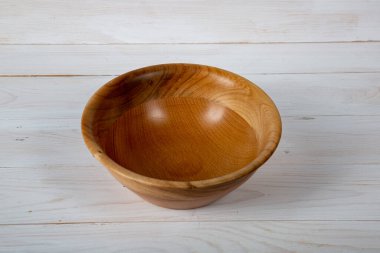 El yapımı ahşap masa takımı ve beyaz tahta arka planda parlak bir ciltli yüzey. Değerli ahşaptan yapılmış sofra takımı..