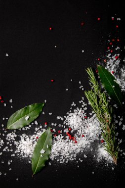 Arka plan defne yaprakları, siyah ve kırmızı biber ve deniz tuzu ile kaplıdır. Menü tasarımı için kumaş arkaplanı.