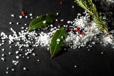 Arka plan defne yaprakları, siyah ve kırmızı biber ve deniz tuzu ile kaplıdır. Menü tasarımı için kumaş arkaplanı.