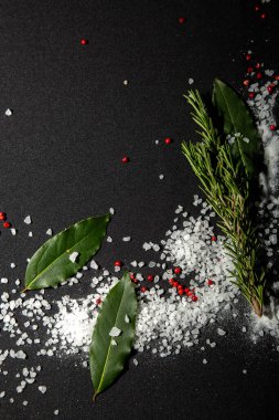Arka plan defne yaprakları, siyah ve kırmızı biber ve deniz tuzu ile kaplıdır. Menü tasarımı için kumaş arkaplanı.