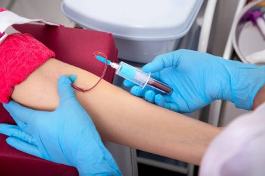 Laboratuvar asistanı tek kullanımlık şırıngayla hastanın damarından kan alıyor. konsept tıp enstitüsünde covid testi.