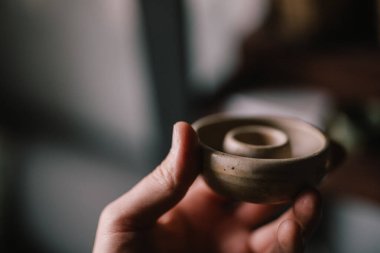 Erkeklerin elinde çömlek ürünü var. Çamurdan yapılmış küçük bir kap. Çömlek ustasının atölyesi. konsept elle yapılan bir hobi.