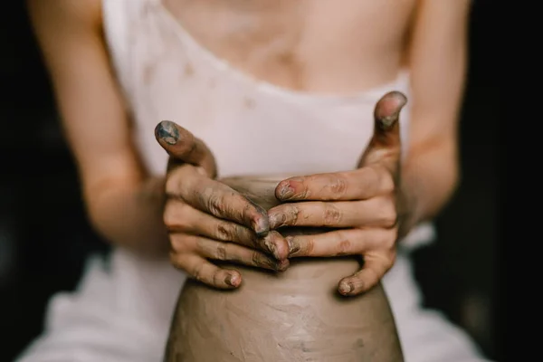 白いシャツを着た若い女の子が陶芸家の車輪の上に粘土のピッチャーを作る 創造的な女性の陶器のワークショップ コンセプト 趣味粘土 — ストック写真