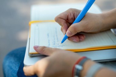 Kot pantolonlu ve beyaz bluzlu danışman kız elinde açık sarı bir defter tutuyor. finansal planlama. Kavram - iş dünyasındaki geleneksel teknolojiler