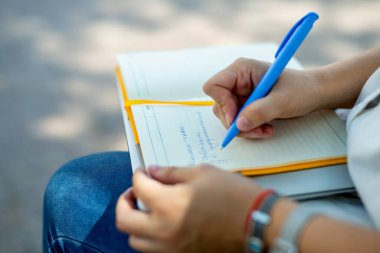 Kot pantolonlu ve beyaz bluzlu danışman kız elinde açık sarı bir defter tutuyor. finansal planlama. Kavram - iş dünyasındaki geleneksel teknolojiler