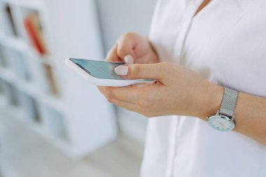 Akıllı telefon elindeydi. Şehir caddesinde gündüz vakti akıllı telefon kullanan kadınların ellerinin yakın plan görüntüleri..