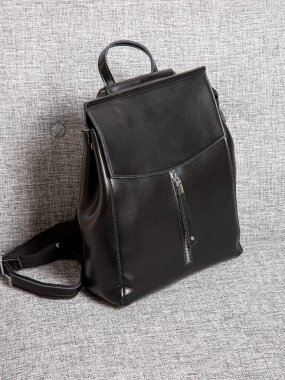 Fermuarlı kayışlı siyah sırt çantası. Eşyalar, aksesuarlar ve ders kitapları dairenin içinde..