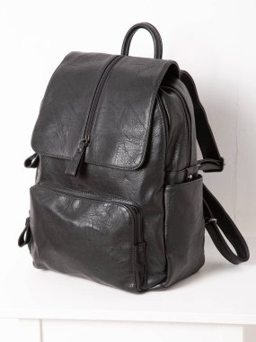 Fermuarlı kayışlı siyah sırt çantası. Eşyalar, aksesuarlar ve ders kitapları dairenin içinde..