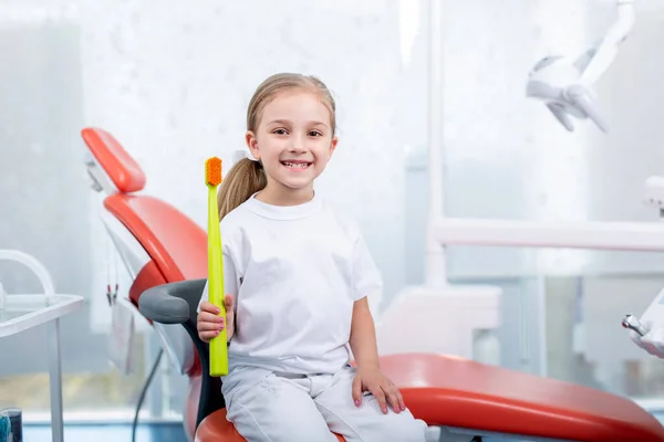 Dziewczynka Białych Ubraniach Recepcji Dentysty Dziecięcego Uśmiecha Się Śmieje Mała — Zdjęcie stockowe