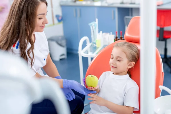 Dentysta Dziecięcy Daje Małej Dziewczynce Duże Zielone Jabłko Piękna Dziewczyna — Zdjęcie stockowe