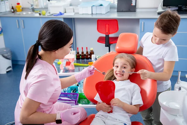 Дитячий Стоматолог Оглядає Зубну Порожнину Маленької Дівчинки Хлопчик Допомагає Маленькій — стокове фото