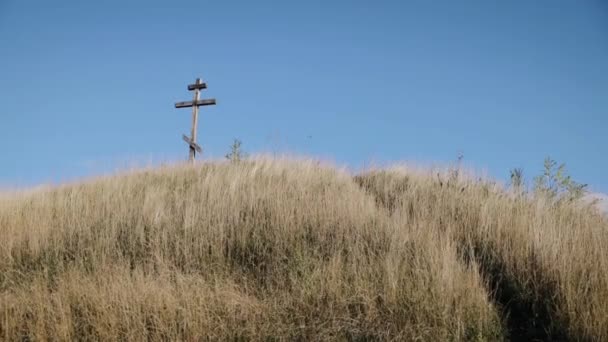 Uma cruz de madeira se eleva sobre uma colina. Outono dia ensolarado no topo. Cruz antiga medieval, cruzadas — Vídeo de Stock