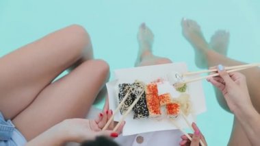 Aperatif suşi yemek seti. Yemek çubuklarıyla alınan kadınların elleri lezzetli taze rulo Philadelphia. Görüntüleri kapat. Geleneksel mutfak. Ulusal yemekler