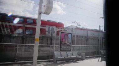Tel Aviv City station platform view from inside of rail wagon thats moves forward with the same speed as another train that passing a station. Israelian railways