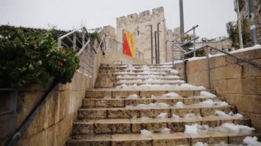 İsrail 'in Eski Kudüs şehrinin batı ucundaki Jaffa Kapısı' nın sabit açılı girişinden alçak görüş açısı. Merdivenlerde kar, ünlü simgeyi takip eder.