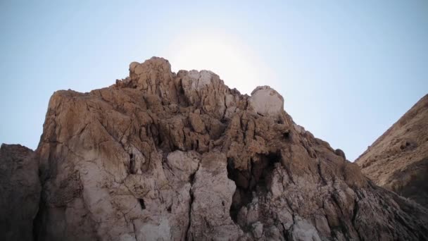 Vista de cerca de la roca. La luz del sol está en el cielo azul claro. Roca de montaña en el desierto cerca del Mar Muerto — Vídeos de Stock