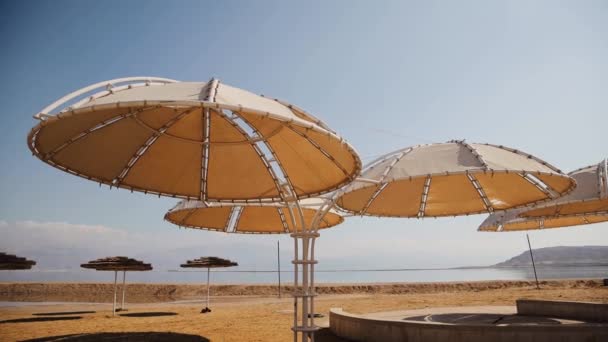 Lots of umbrellas for protection against sun is on the hotels beach near the Dead Sea — Video