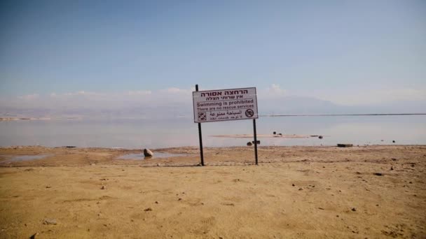 Varning, simning är förbjudet, det finns ingen räddningstjänst, risk för drunkning. Tecken på hebreiska och arabiska språket som betyder - simning är förbjudet — Stockvideo