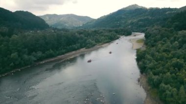 Dağ manzarasının tepesinden hava manzarası ve teknelerin açıldığı dağ nehri. Dağın eğimli nehrinde rafting yapmak.