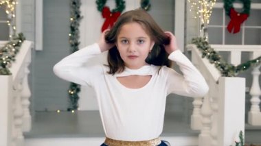 Noel gecesi evin yakınındaki kameraya gülümseyen ve poz veren bir kızın portresi..