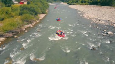 Rafting için dağ nehrinde rafting yapan bir sürü tekne. Kayalıklar ve hızlı su, dağlık bir nehirde bir tekne için engel teşkil eder..