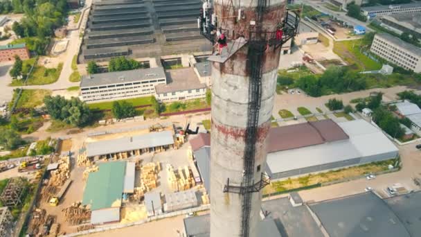 Aerial view man jumps from an extremely high height upside down. Rope jumping from the pipe of an abandoned factory. — Stock Video