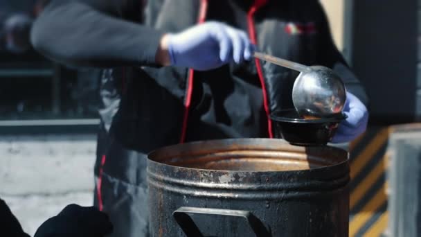 Le cuisinier met la soupe dans une assiette. Nourriture de rue pendant le festival. — Video