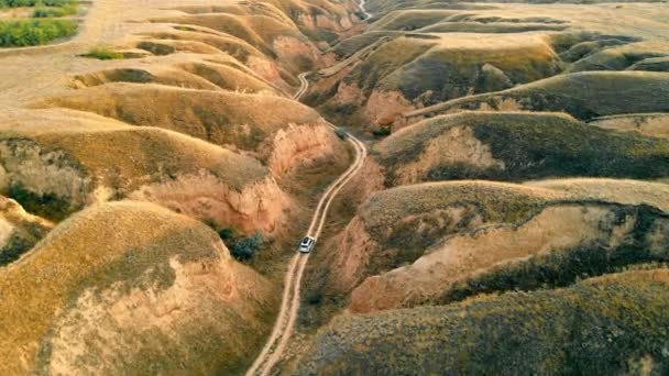 Vista aérea Carros que viajam no desfiladeiro em uma estrada de terra entre grandes montanhas de areia. Paisagem incrível canyon no parque nacional. — Vídeo de Stock