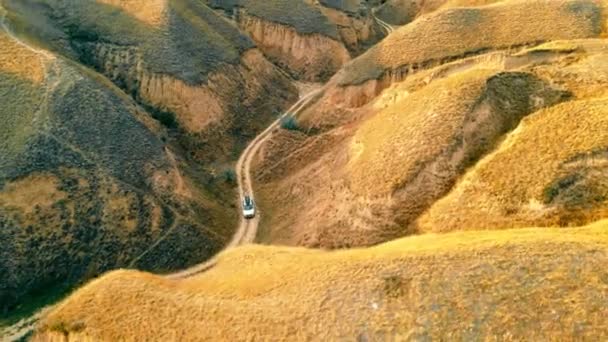 Aerial view Autók utazik a kanyonban egy földúton között nagy homokos hegyek. Hihetetlen kanyon táj a nemzeti parkban. — Stock videók