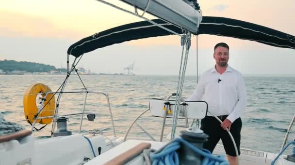 Капітан яхти, який знаходиться на шоломі, керує яхтою за вечерею. Подорож на човні за вечерею . — стокове відео