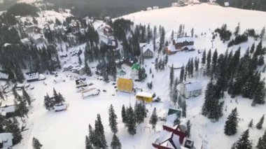 Kış mevsiminde karla kaplı büyük bir turist şehri üzerinde uçmak. Evler ve sokaklar karla kaplı..