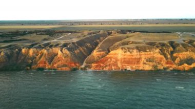 Kum kayalıkları ve deniz kıyısındaki uçurumlar. Sahilde kum dağları olan inanılmaz deniz manzarası..
