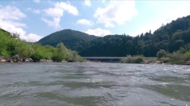 Dağ nehri üzerinde dinamik kamera hareketi. Suya daldırma. Nehirde boğulan bir adamın bakışları..