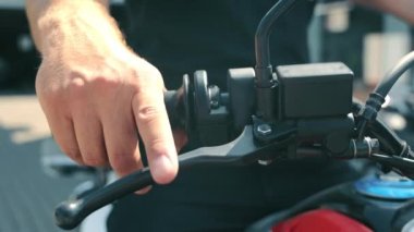 Eldivensiz bir motosikletin gaz pedalındaki erkek eli. Dostum, frene bas ve motorun sapını gazla..