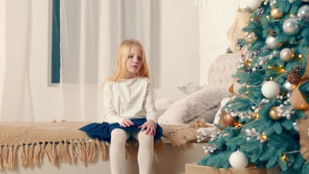Maman donne à une petite fille une boîte avec un cadeau de Noël. Triste petite fille reçoit une boîte blanche avec un ruban rouge comme cadeau pour les vacances de Noël — Video