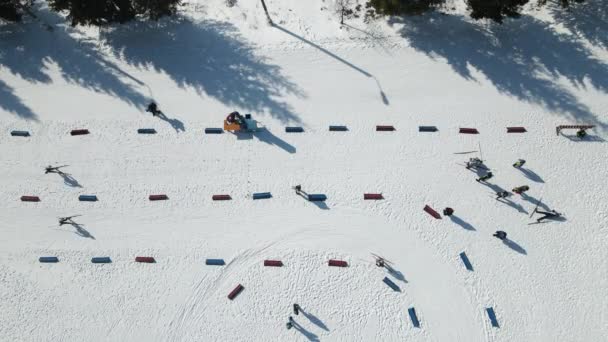 Зимовий спортивний біатлон. Учасники долають дистанцію і закінчують. Спортсмен закінчується і падає на сніг. Зимові змагання з лижного спорту — стокове відео