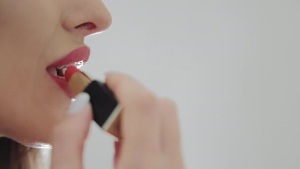 Pretty woman paints lips close up side view. — Stock Video