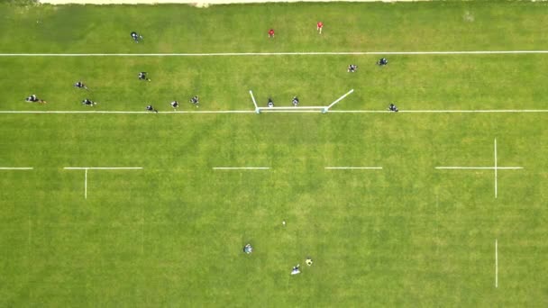 Vista aérea Los jugadores de rugby luchan por el balón. Jugando rugby en un gran campo verde. — Vídeos de Stock