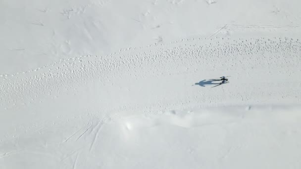 Egy biatlonverseny résztvevőjének légi felvételei. A sportoló felülkerekedik a sílécek távolságán.. — Stock videók