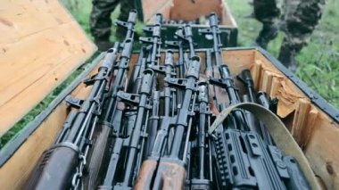Ordu Kalaşnikof saldırı tüfekleri ve keskin nişancı tüfeklerini bir kutuya koydu. Askeri teçhizat boşaltılıyor. Yakından bakınca tahta bir kutuya, Kalaşnikof tüfeği ve keskin nişancı tüfeği koyuyor..