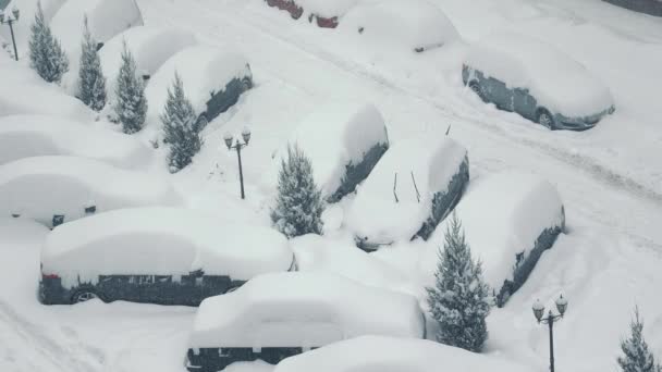 Les voitures sont recouvertes de neige après une tempête de neige. De fortes chutes de neige. Les rues et les voitures sont couvertes de beaucoup de neige. Le parking était couvert de fortes chutes de neige. — Video